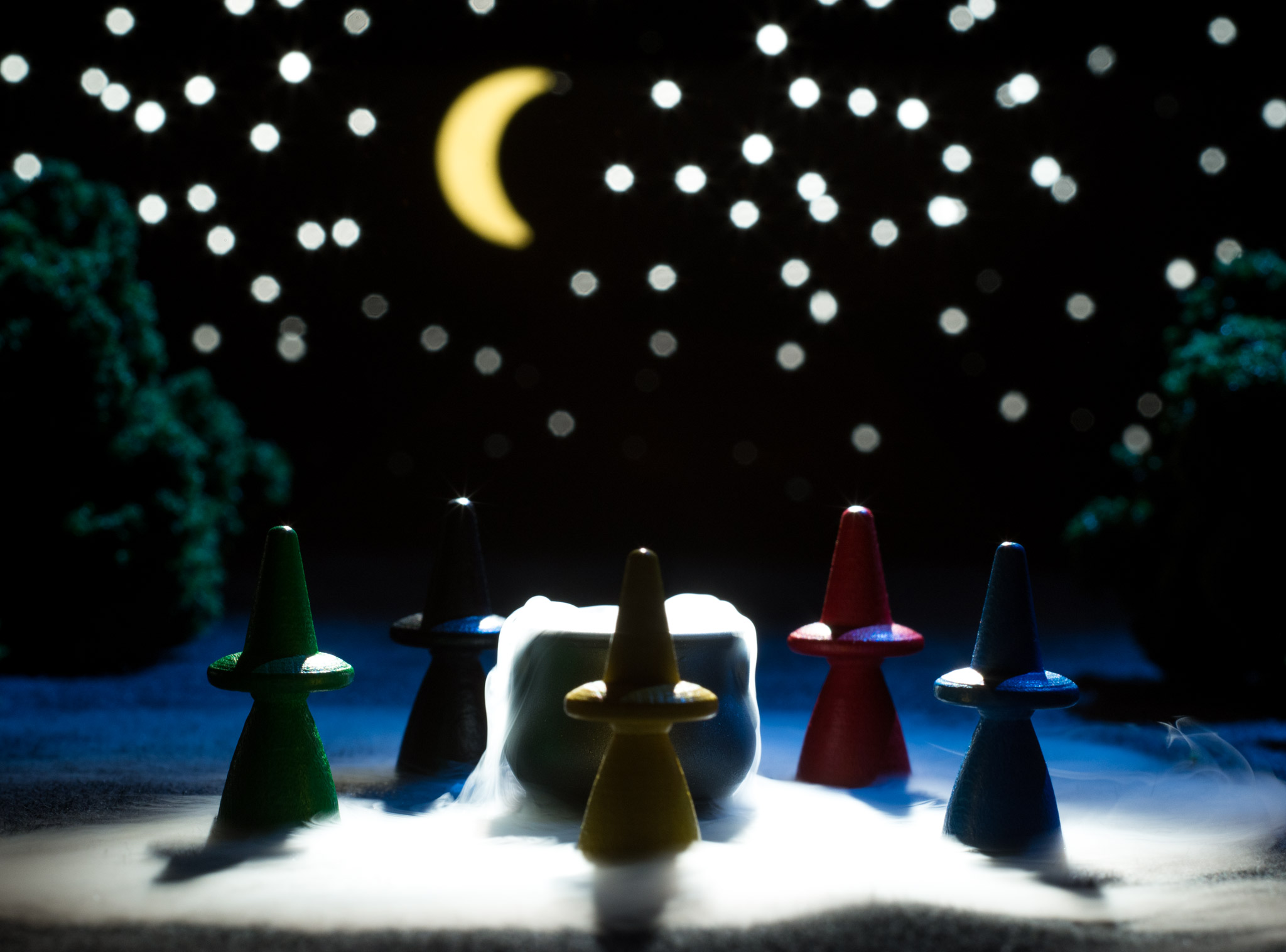 Witches surround a cauldron at night from Broom Service tabletop board game