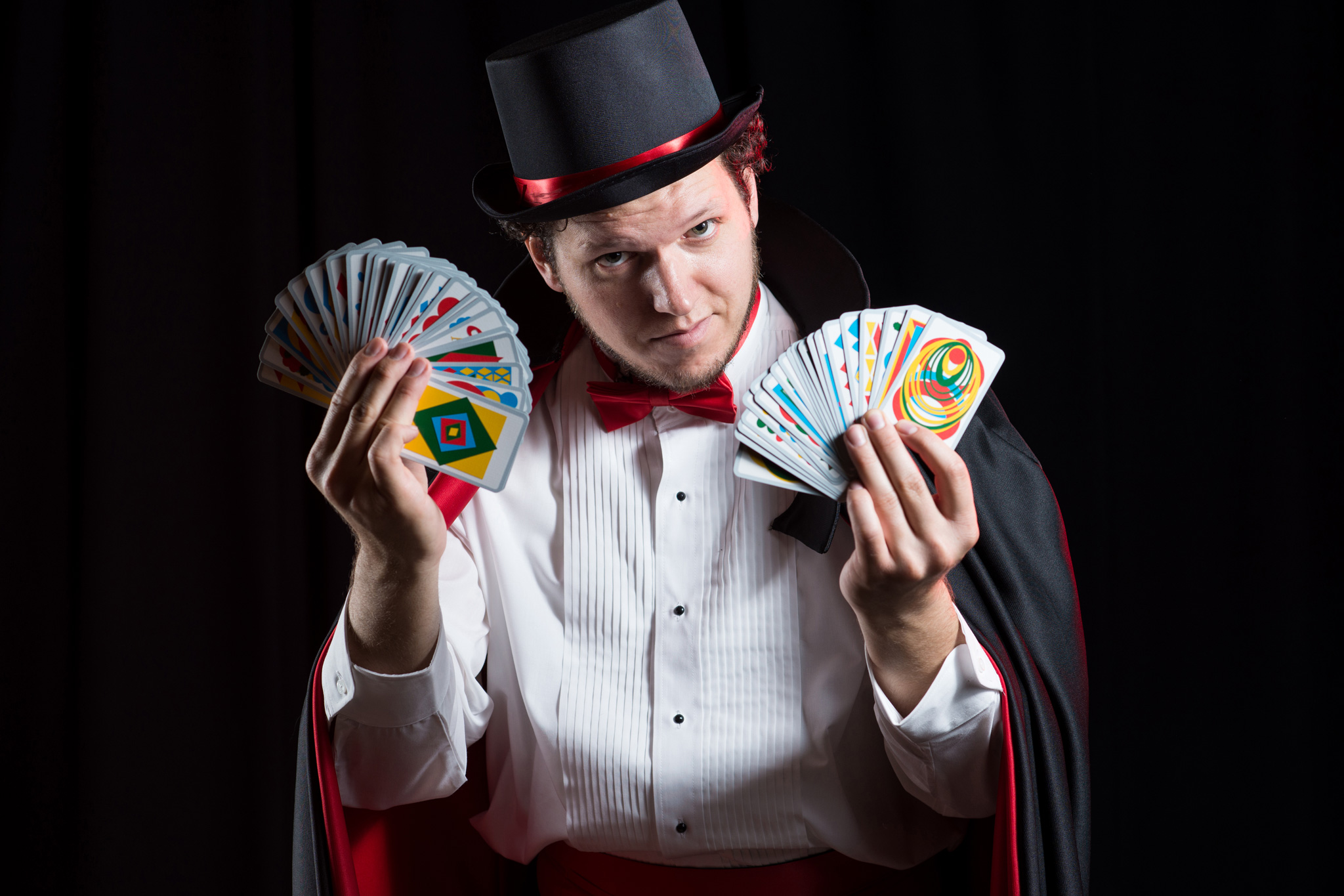 Magician fanning out the cards from the tabletop game Illusion