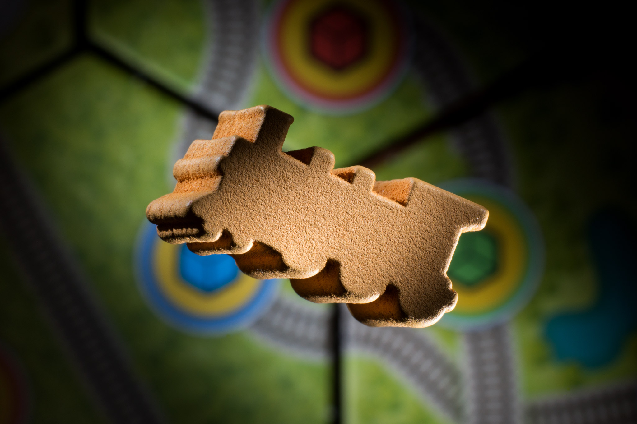 A stylishly lit train meeple from Whistle Stop floats over some hex tiles